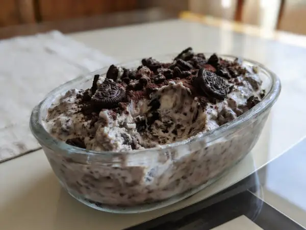 Pyszne lody oreo w szklanej misie, posypane pokruszonymi ciastkami i kakao. Idealne na deser!