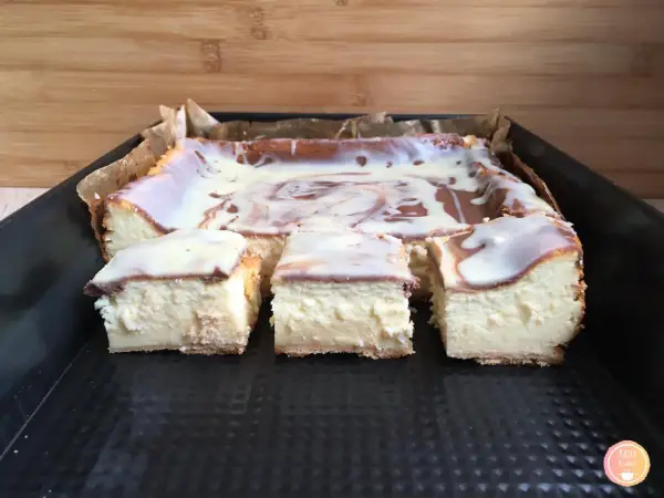 Pyszny sernik z polewą, pokrojony na kawałki. Czy do sernika dodaje się proszek do pieczenia? Ten wygląda idealnie!